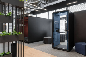 Black acoustic pods with planters on the coworking floor